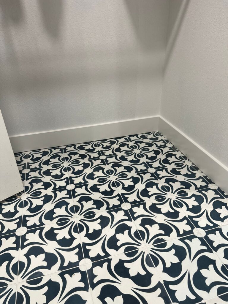A floor with white and blue patterned tiles.