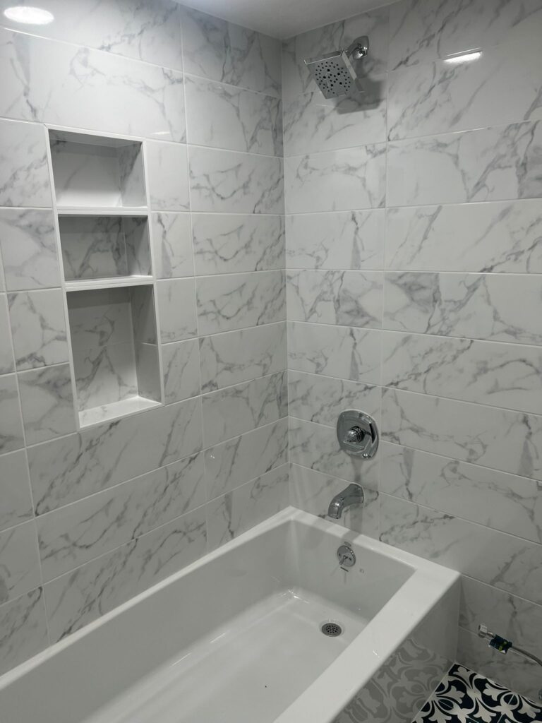 A modern bathroom with a glass shower and floating vanity.